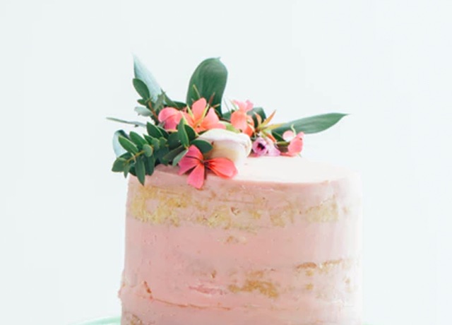 A pink cake, decorated by pink flowers.